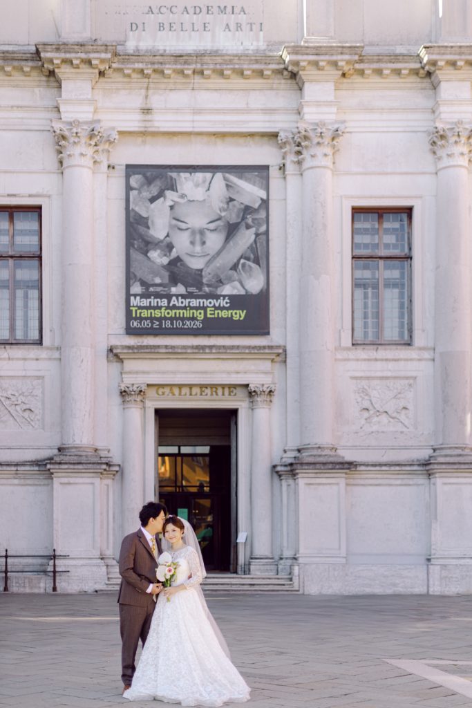 Couple in wedding outfits at the entrance of the Gallerie dell'Accademia, Venice
