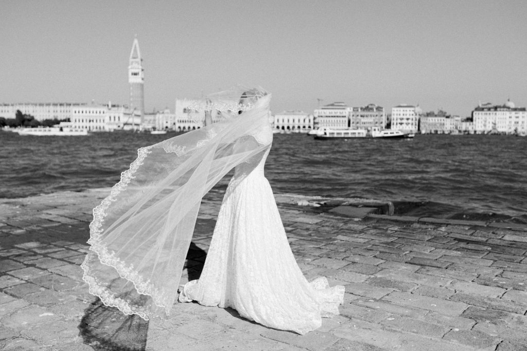 Bride playing with the veil in wedding attire at San Giorgio Maggiore in Venice