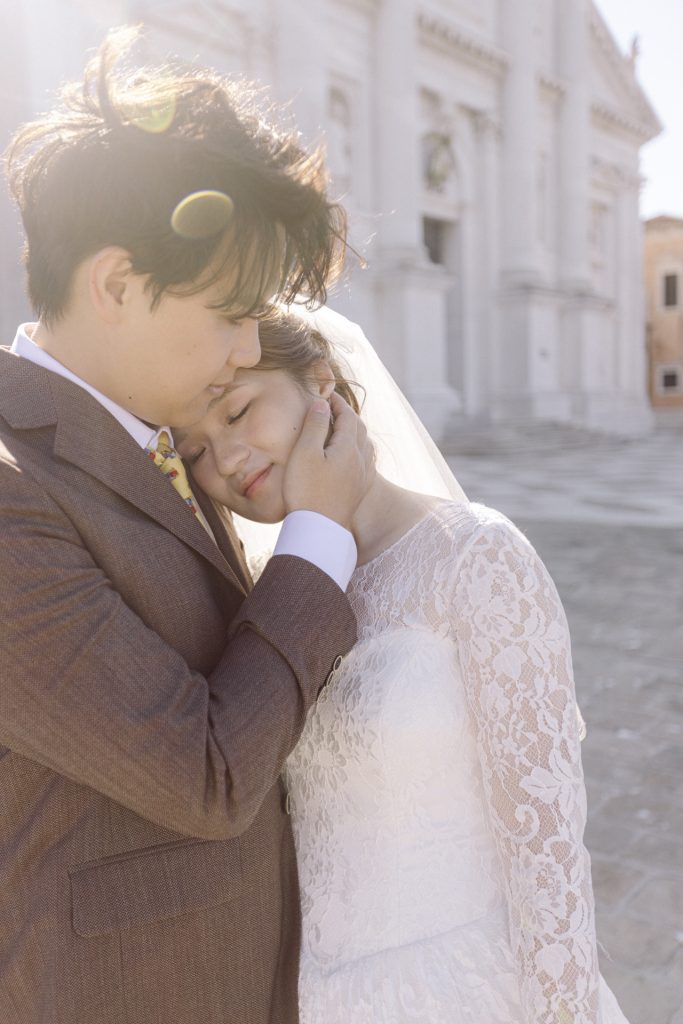 Couple tenderness in wedding attire at San Giorgio Maggiore in Venice
