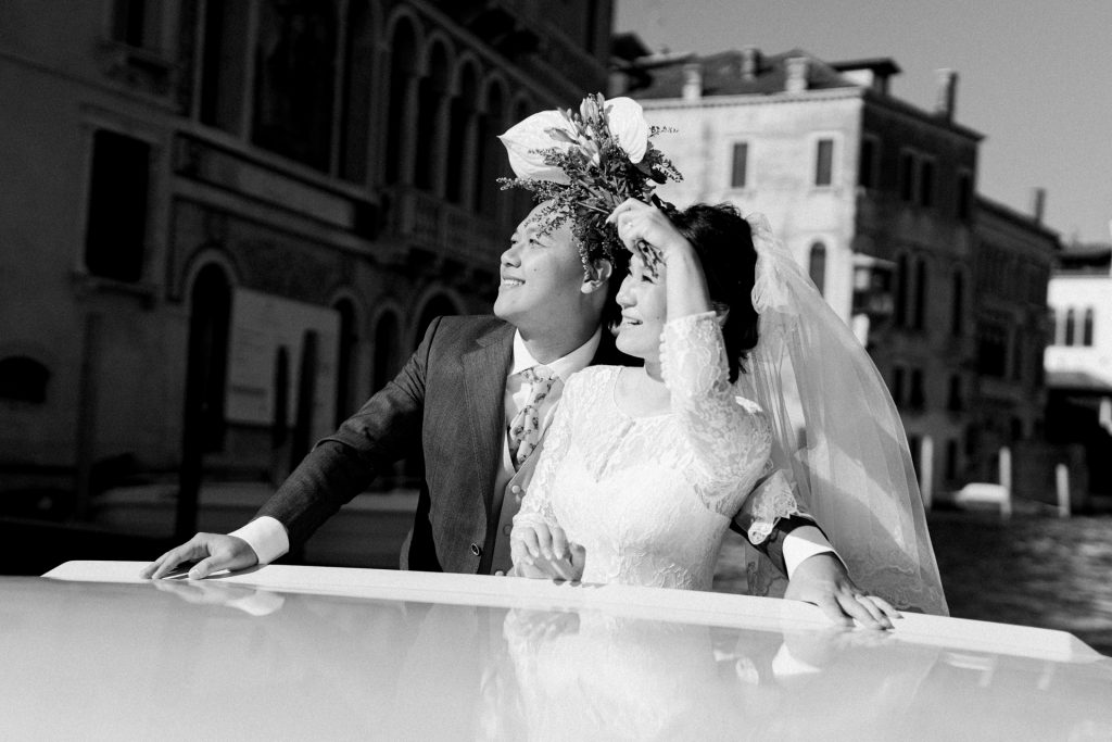 Couple in wedding attire on a water taxi on the Grand Canal in Venice 