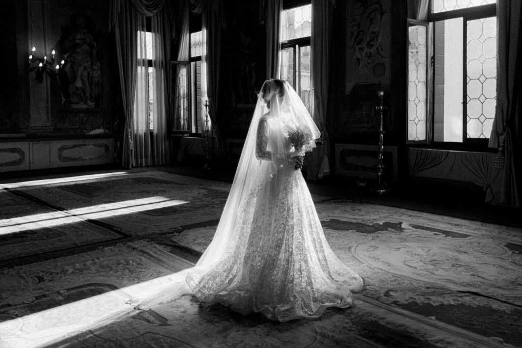 Bride in wedding attire posing for wedding portraits at Ca’ Sagredo, Venice black and white